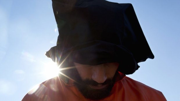 A protester wearing an orange jumpsuit depicting a Guantanamo Bay detainee, participates in a rally outside the White House in Washington last month that  called for the prison's closure.