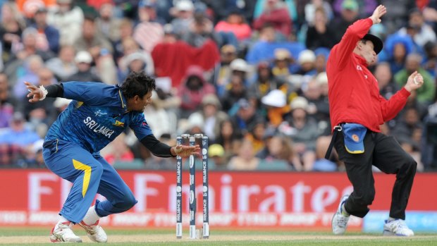 Sri Lanka's Suranga Lakmal, left, and umpire Nigel Long, right, take evasive action.