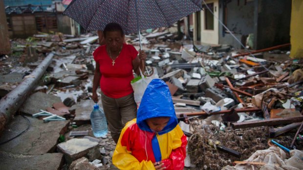 A boy and a woman walk through houses destroyed by Hurricane Matthew in Baracoa, Cuba, on Wednesday.