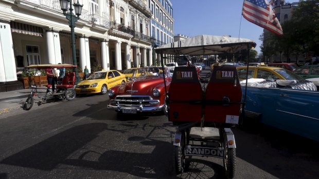 A tricycle taxi with a US flag parked on a street in Havana on Sunday. 