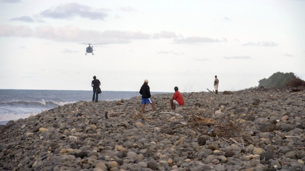 Helicopters search for debris: People walk on the beach of Saint-Andre, Reunion Island.