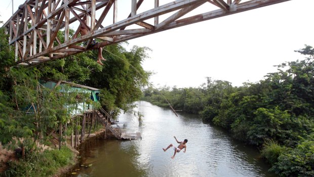 A young man jumps from an overpass into a river in Paragominas, northern state of Para near the reserve the Brazilian government wants to abolish to make way for mining.