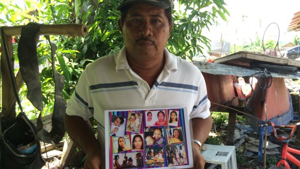 Pedro Lacandazo, 50, holds a photo of the family members he lost in Haiyan. They are among more than 40 members of his extended family who were lost.