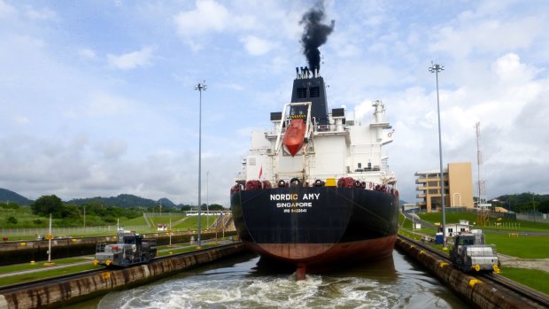 A tanker passing through Miraflores lock, guided by electronic "mules".