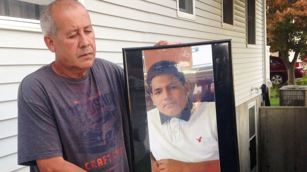 Abraham Chaparro holds a photograph of his murdered stepson, Miguel Garcia-Moran.