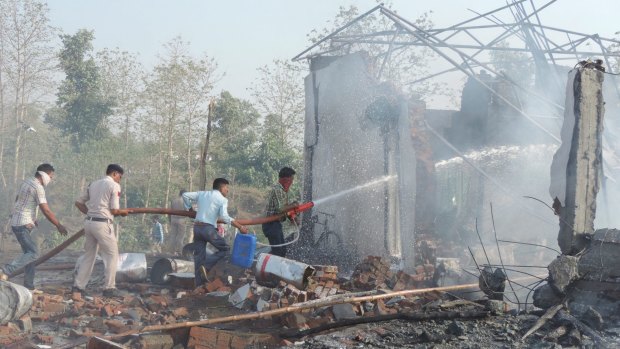 Rescuers try to douse the fire after an explosion in a firecracker factory in Balaghat, India, on Wednesday.
