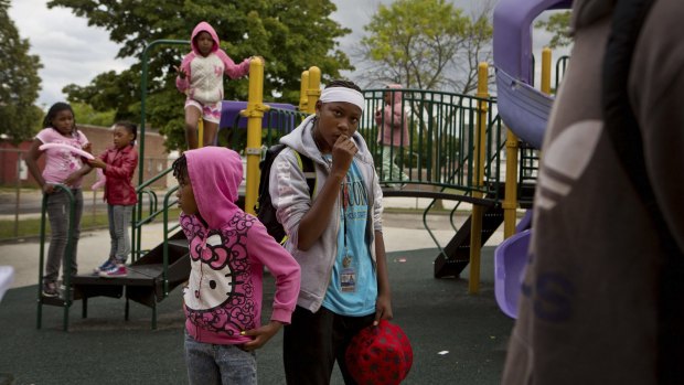 Essence Gilchrist, 15, centre, with Amiya Singleton, 7, on an elementary school playground in the north side of Milwaukee, a city that has had a steep rise in murders this year.