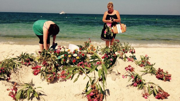 DonnaMarie Douglas from Glasgow (right) and a friend lay flowers at the makeshift memorial on the beach in front of the Hotel Imperial Marhaba.