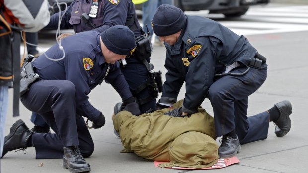 Police arrest a demonstrator protesting against the police shooting of a 12-year-old boy who was fatally shot by a Cleveland police officer.