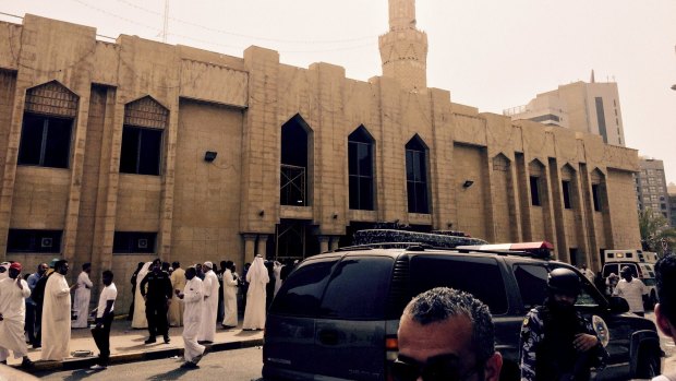 Police control the crowd in front of the Imam Sadiq Mosque after a bomb explosion, in the Al Sawaber area of Kuwait.