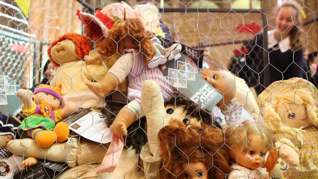 Children look at a cage filled with dolls inside  St John's Anglican Cathedral in Brisbane, representing the 895 child asylum seekers in detention.