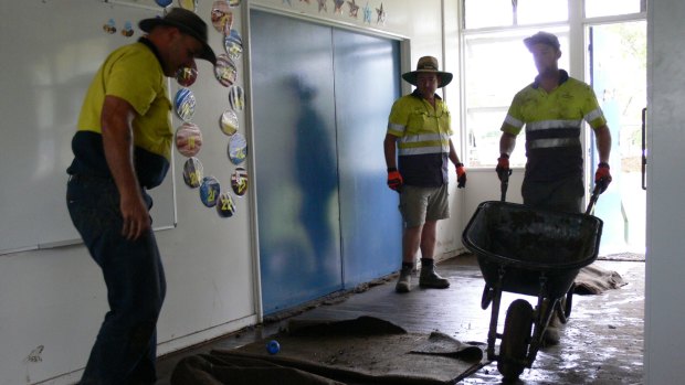Workers clean up Clarke Creek State School after the deluge following Cyclone Debbie.