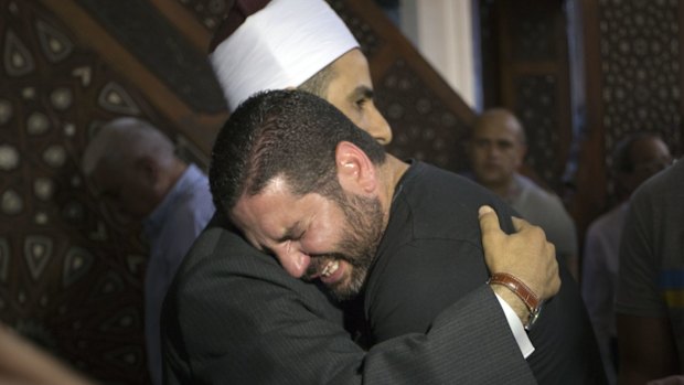 The Imam of al Thawrah Mosque, Samir Abdel Bary, gives condolences to film director Osman Abu Laban, center, who lost four relatives, all victims of Thursday's EgyptAir plane crash.