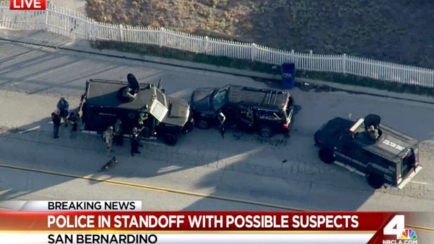 Armored vehicles surround an SUV following a shootout in San Bernardino.