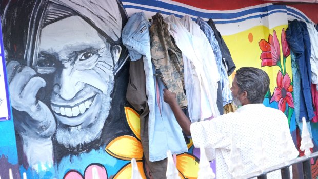 A man checks out a garment left at the Wall of Kindness in Bhilwara, India. 