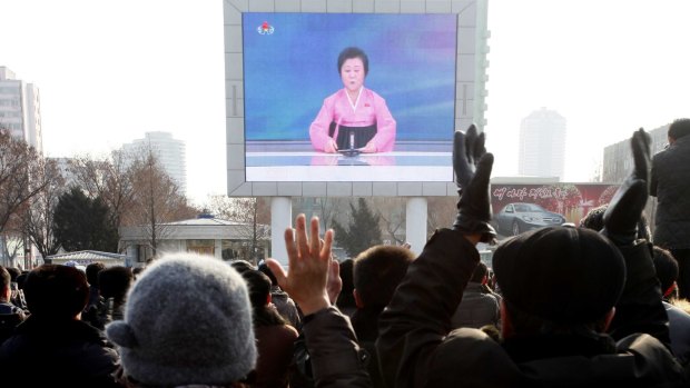 North Koreans watch a news broadcast on a video screen outside Pyongyang Railway Station in North Korea on Wednesday.