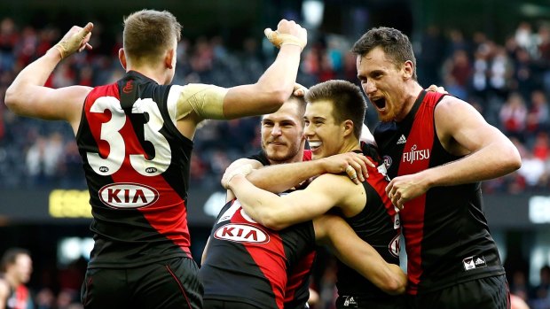 Acting Essendon captain Zach Merrett (second from right) celebrates on the final siren with Jayden Laverde (left) David Zaharakis and Matthew Leuenberger (right) after the round 21 win against Gold Coast. 