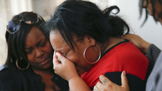 Relatives comfort Tambrasha Hudson on Tuesday as she cries over the shooting death of her 16-year-old son, Pierre Loury, by a Chicago police officer.