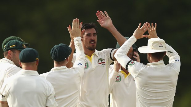 Australia paceman Mitch Starc (centre) is congratulated by his teammates on the second of his three wickets with the second new ball that were crucial in them having to chase on 47 for victory against the West Indies late on day three of the first Test at Windsor Park, Dominica.