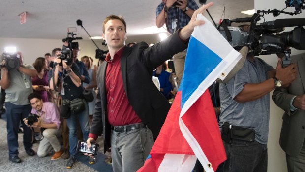 A protester who identified himself as Ryan Clayton brought a Russian flag to Capitol Hill.