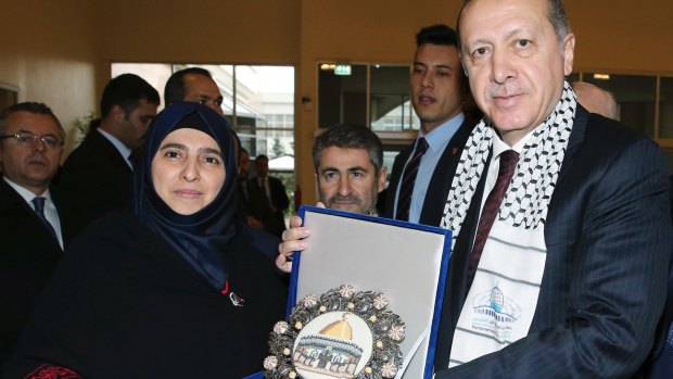 Turkish President Recep Tayyip Erdogan receives a picture of Jerusalem's Dome of the Rock from a Palestinian woman before addressing a symposium on Jerusalem in Istanbul in November.