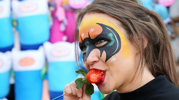 Milli Richards shows exactly how to enjoy a strawberry on a stick at the Ekka. 