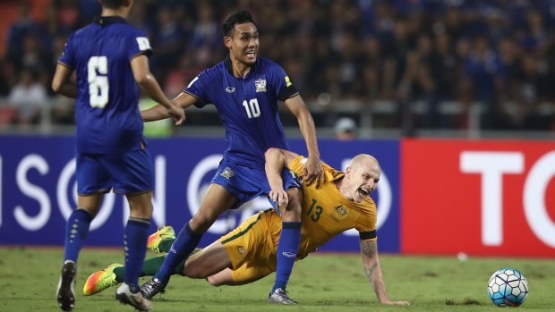 Teerasil Dengda of Thailand tackles the Socceroos' Aaron Mooy during the 2018 FIFA World Cup Qualifier.