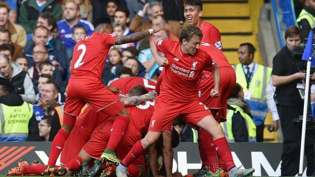 Double delight: Phillipe Coutinho is mobbed after scoring his second goal.