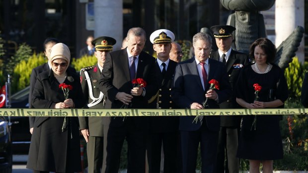 Finnish President Sauli Niinisto, front row second right, Turkish President Recep Erdogan, front row second left, and their wives, offer carnations at the site of deadly Saturday explosions in Ankara on Wednesday.