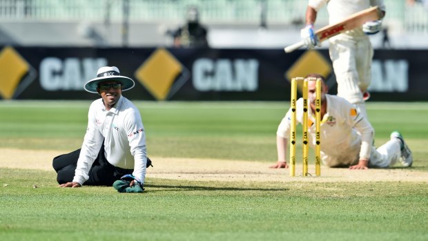 Umpire Kumar Dharmasena (left) is forced to take evasive action India's Virat Kohli blasts a ball straight back at Australia off-spinner Nathan Lyon on day three of the Boxing Day Test.