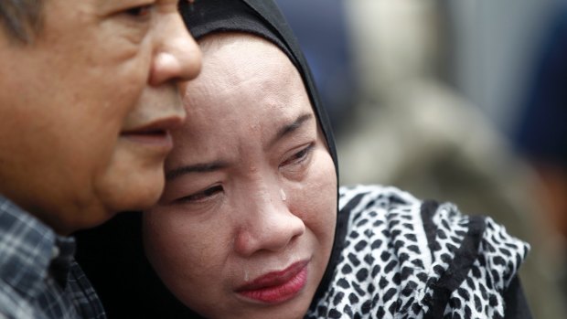 Family members cry outside an Islamic religious school on the outskirts of Kuala Lumpur following a fire on Thursday.
