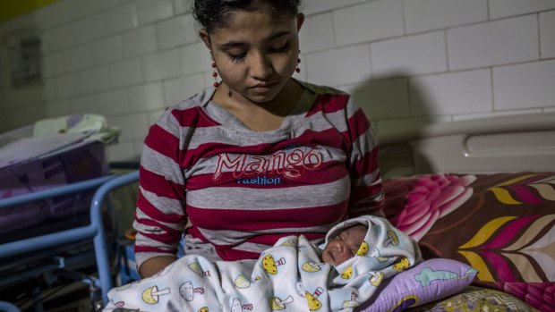 Rohingya refugee Samsidar, 15, holds her two-day-old baby at a hospital in Bayeun, Aceh. Persecution of the Muslim minority has escalated in recent years.