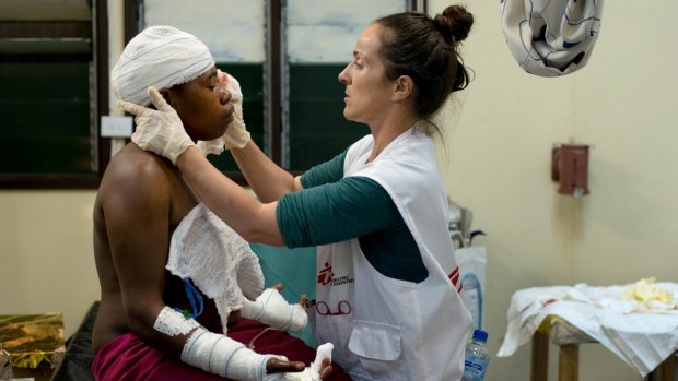 Irish nurse Aoife Ni Mhurchu treats a patient last year at Tari Hospital in the highlands region of Papua New Guinea. The woman sought treatment for lacerations after her husband cut her with a knife on the back of her head and both hands.
