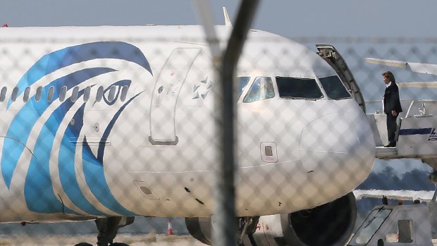 A crew member of the hijacked EgyptAir aircraft on the passenger boarding stairs after landing at Larnaca airport on Tuesday.
