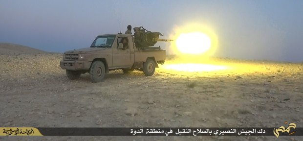 An Islamic State militant opens fire during a battle against Syrian government forces in Homs in July.
