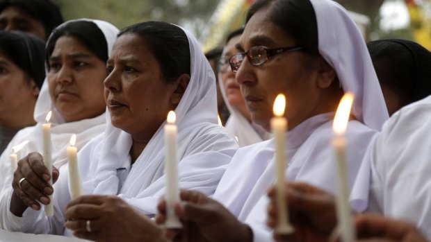 Pakistani nuns hold candles during a vigil for victims of Sunday's deadly suicide bombing in a Lahore park, on Monday.