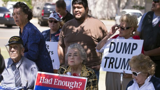 People hold signs as they gather to protest the visit of Republican presidential candidate Donald Trump on Texas last week.