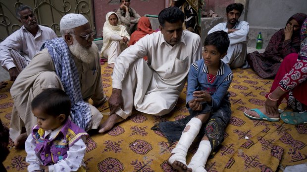 Fahd Ali, 10, right, who was injured in the bombing that killed his parents and sister and wounded two sisters, narrates his ordeal to visitors in Lahore on Monday.
