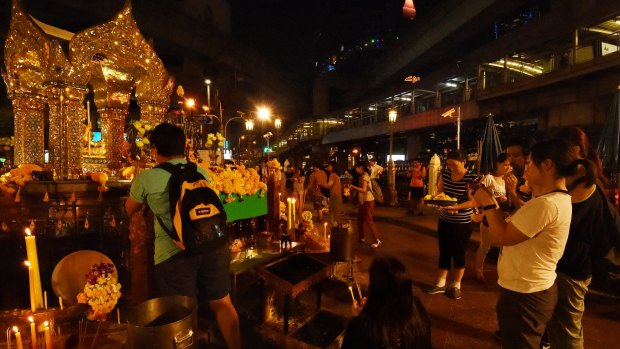 People pray at Erawan Shrine in Bangkok on Thursday following the death of the King.