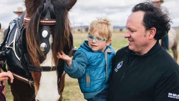 Paul Dowden and his three-year-old son Sebastian enjoy the horses on the Majura Road property Springfield on Friday.