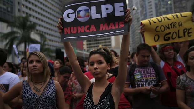 A supporter of Dilma Rousseff holds a banner reading "Coup Never Again" during a demonstration in Rio de Janeiro on Thursday.