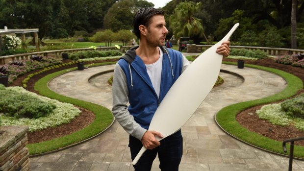 Indigenous artist Jonathan Jones holding one of the 15,000 ceramic Aboriginal shields he is installing in Sydney's Royal Botanic Gardens.