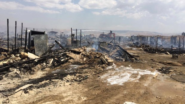 Lebanese Civil Defence workers put out a fire in the Qab Elias refugee camp in Lebanon.