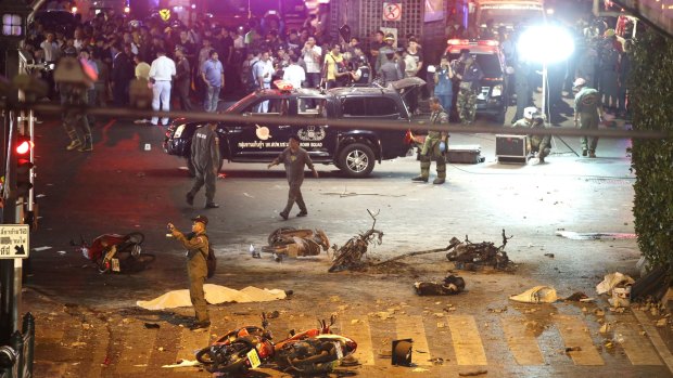 A policeman photographs debris after the August 17, 2015, explosion in central Bangkok.