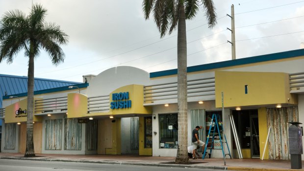 Store owners board up their properties in Miami Beach, Florida.