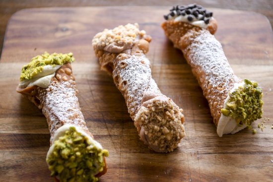 From left: Pistachio, Nutella and classic cannoli piped with ricotta-based fillings and dipped in crushed nuts and/or chocolate chips.