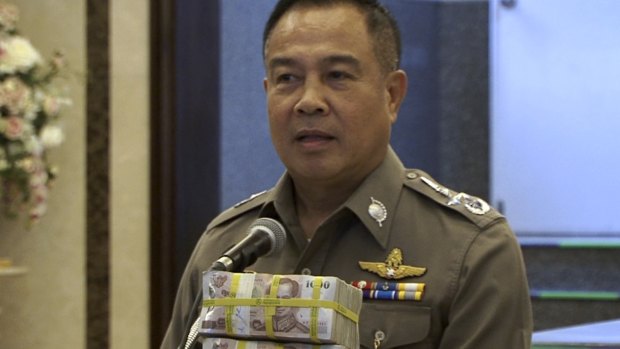 National Police Chief Somyot Poompanmoung shows cash reward for tips leading to the arrest of those responsible for the Bangkok bombing on August 31.