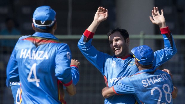 Afghanistan's Mohammad Nabi celebrates with teammates after claiming the wicket of Joe Root.