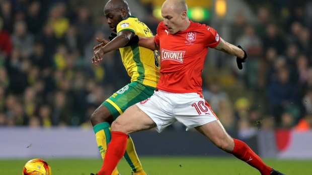 On song: Norwich City's Youssuf Mulumbu and Aaron Mooy battle for the ball at Carrow Road.