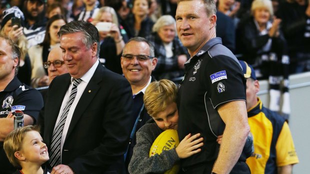 Magpies coach Nathan Buckley is hugged by his son after their win against undefeated Geelong as Pies president Eddie McGuire looks on. 